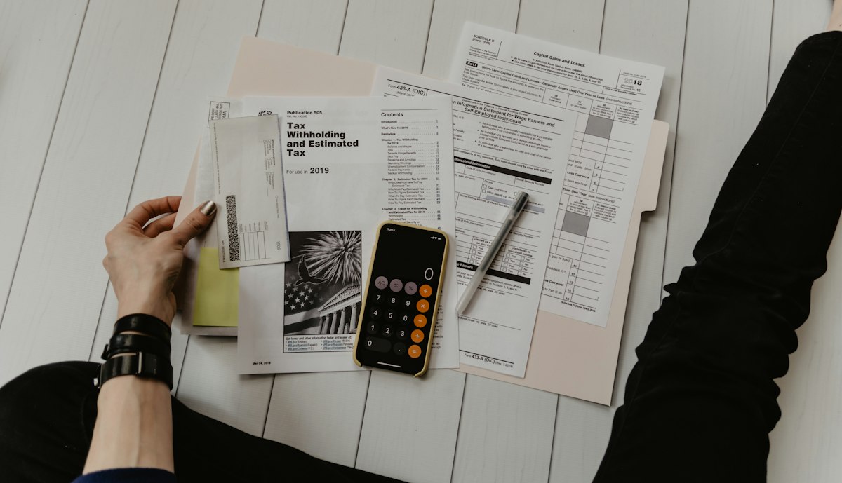 Handwritten notes beside a calculator for project cash planning